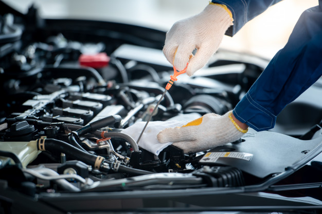 Professional mechanic changing engine oil - VW vehicle maintenance